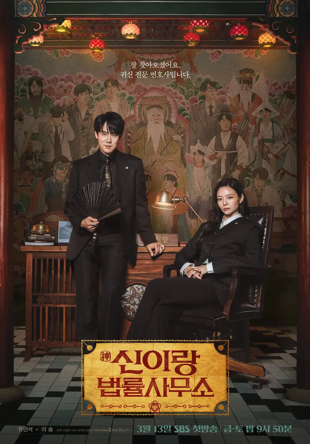 신랑과 신부 복장을 한 남녀 주인공이 전통 사무실 배경 앞에서 정장 차림으로 앉아 있으며, 화려한 한옥과 벽화가 강조됨.