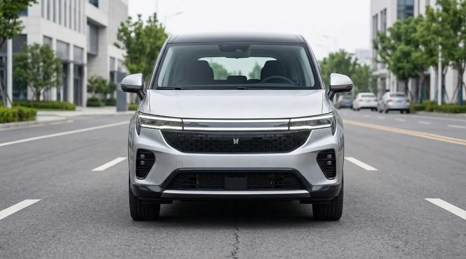 전면 로드뷰에서 현대적인 디자인의 은색 전기차가 도심 거리 한가운데 정차해 있고, 주위에는 나무와 현대식 건물이 조화를 이룬다.