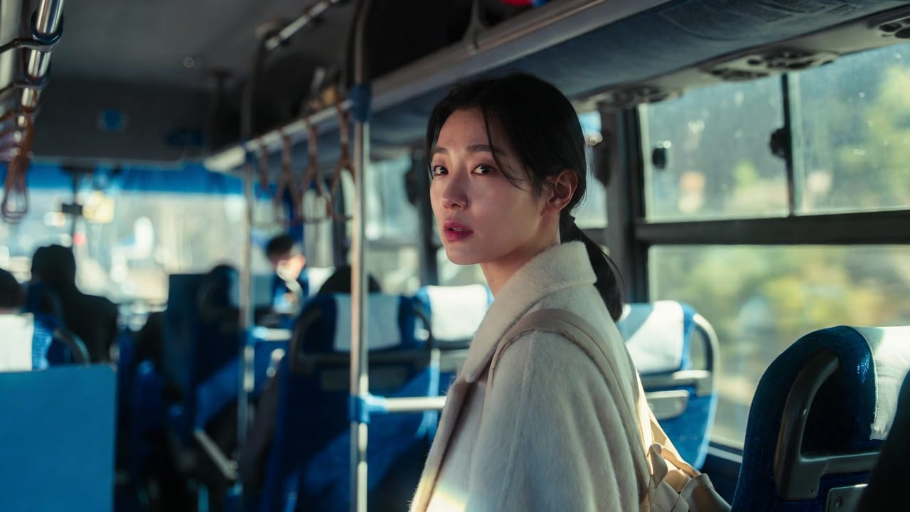 여성 승객이 겨울 코트를 입고 버스 좌석에 앉아 창밖을 바라보며 생각에 잠긴 자연스러운 도시 대중교통 장면.