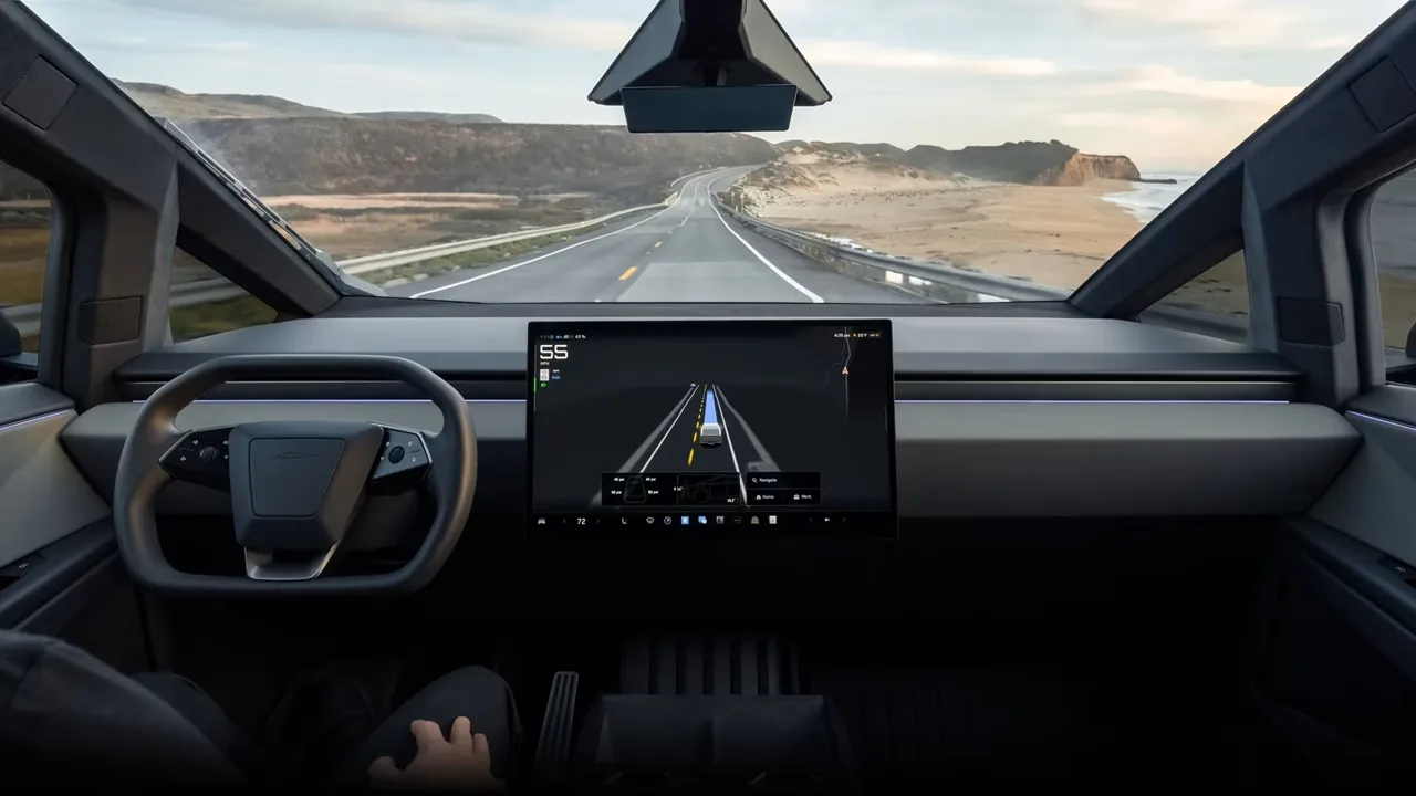 전방 도로와 내비게이션 화면이 보이는 전기차의 내부 모습. 스티어링 휠과 대형 디스플레이가 특징이며, 주행 속도와 경로 정보가 표시됨.