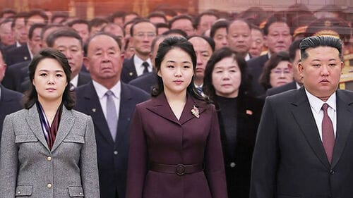 김정은과 그의 가족, 그리고 고위 관료들이 대중 앞에 서 있는 모습. 중앙에 김정은의 딸과 아내가 위치해 있으며, 뒤에는 여러 명의 관료들이 함께하고 있다. 이들은 공식 행사에 참여하고 있는 장면으로, 북한의 정치적 상황을 반영한다.