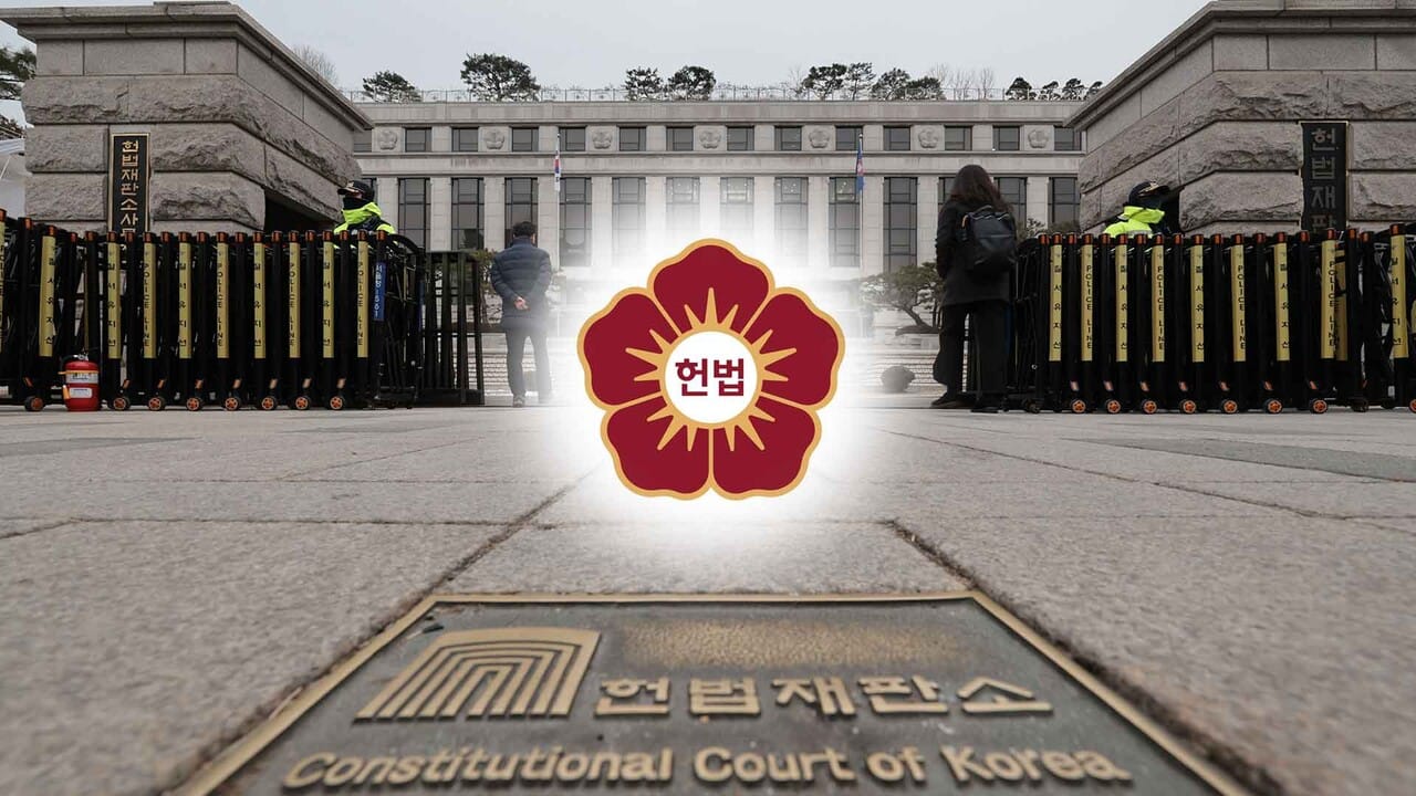 헌법재판소 정문 앞에 서 있는 사람들과 경찰들이 보이는 이미지로, 헌법재판소의 로고와 이름이 강조되어 있습니다. 법원과 법적 절차에 대한 상징성을 나타냅니다.