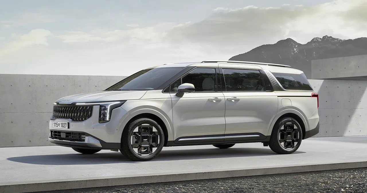 고급스러운 디자인의 현대 SUV 차량이 실외에서 촬영된 이미지로, 독특한 그릴과 세련된 바퀴가 특징입니다. 배경에는 현대적인 건축물과 자연 경관이 어우러져 있습니다.