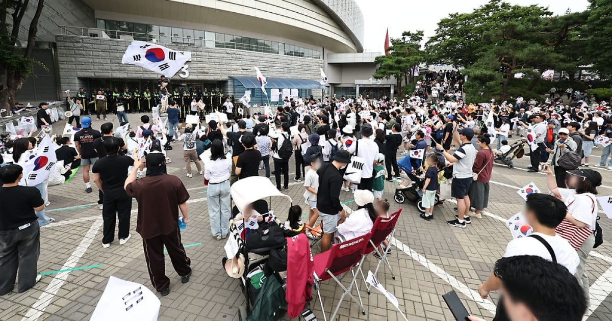 서울에서 열린 대규모 시위 현장, 참가자들이 태극기를 들고 있으며 경찰이 경계하고 있는 모습. 김부장 드라마 관련 논란과 선관위 이슈에 대한 반응을 나타내고 있음.