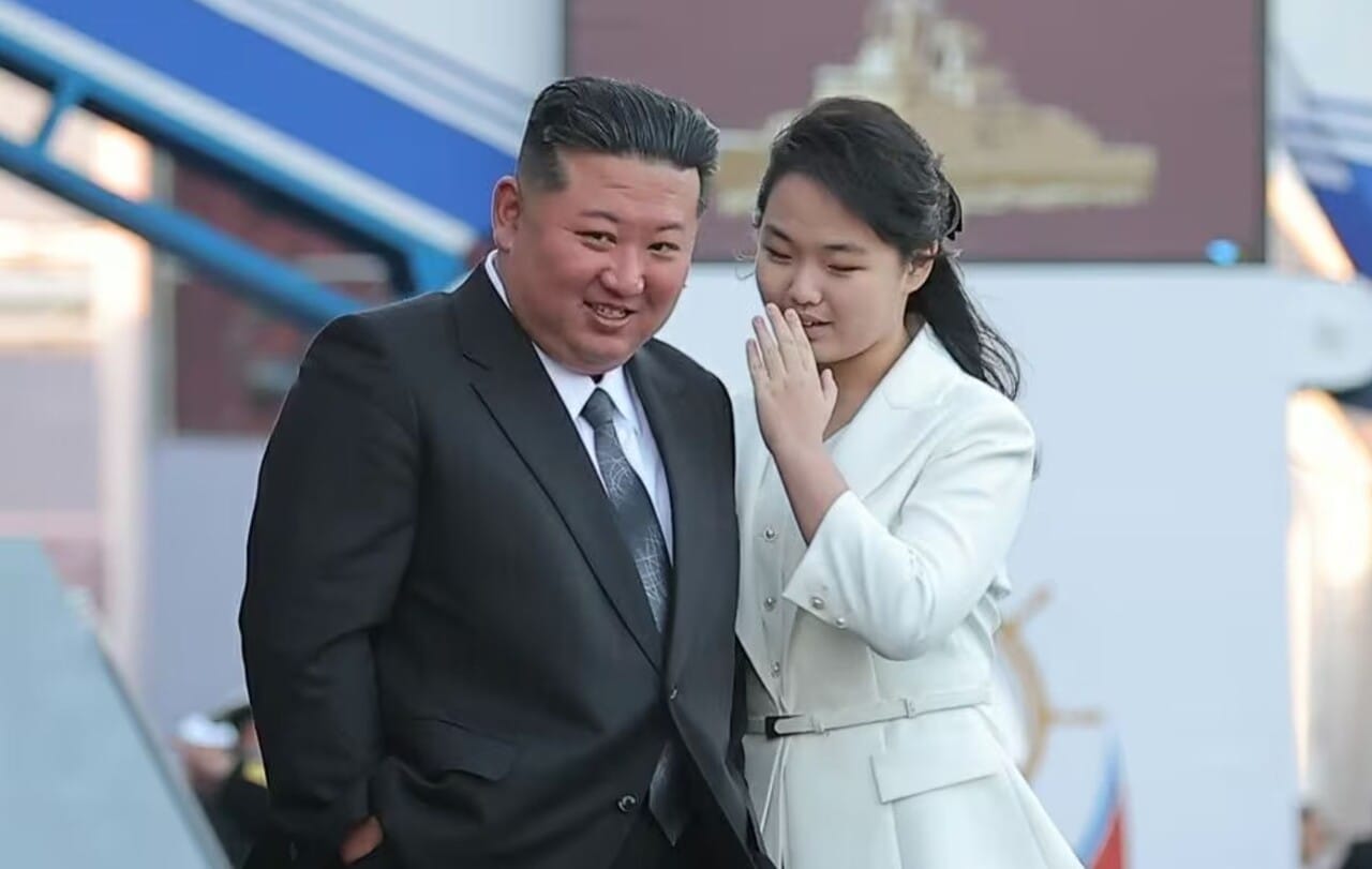 김정은과 김주애가 함께 서서 대화하는 모습. 북한의 정치적 인물 관계를 보여주는 이미지로, 두 사람의 친밀한 순간을 포착.