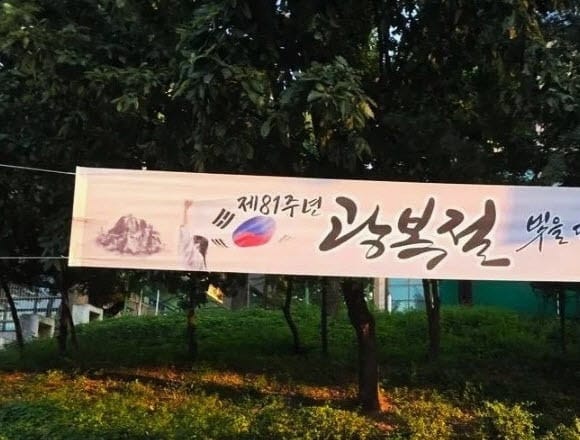 제81주년 광복절을 기념하는 현수막, 태극기와 북한 관련 이미지 포함.